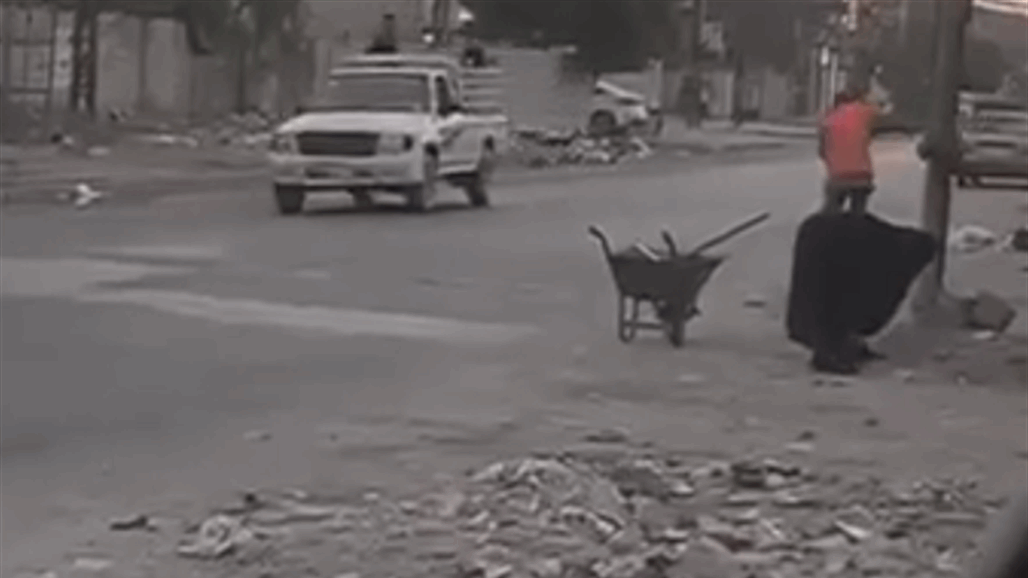 أمرأه تعمل على تنظيف الشوارع في البلدية لإعانة ابنها المعاق