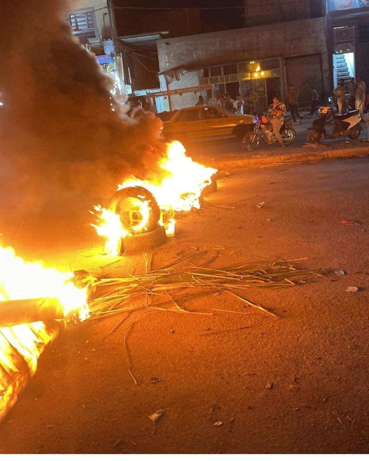 بسبب انقطاع الكهرباء.. محتجون يحرقون الإطارات امام دائرة الكهرباء في حي الشرطة بالنجف