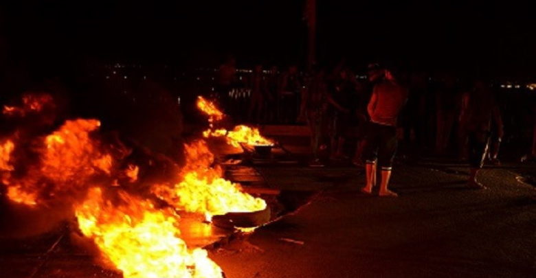 متظاهرون يحرقون إطارات تحت جسر المحاكم في البصرة